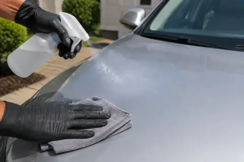 Detailer spray being applied to a car paint surface
